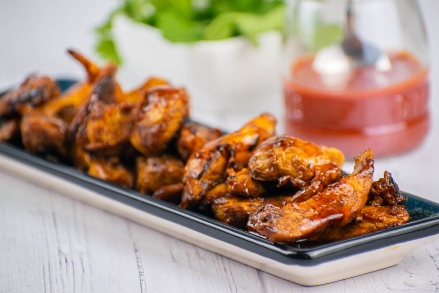 Grilled Sriracha honey chicken on a blue plate.