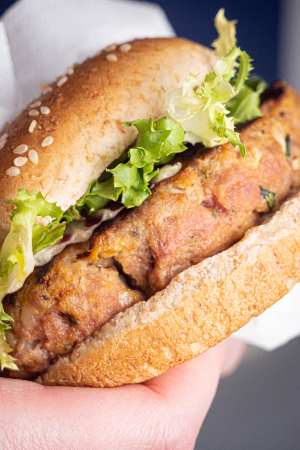 Italian Burgers with tomatoes, spices, and garlic topped with lettuce in a wheat bun.