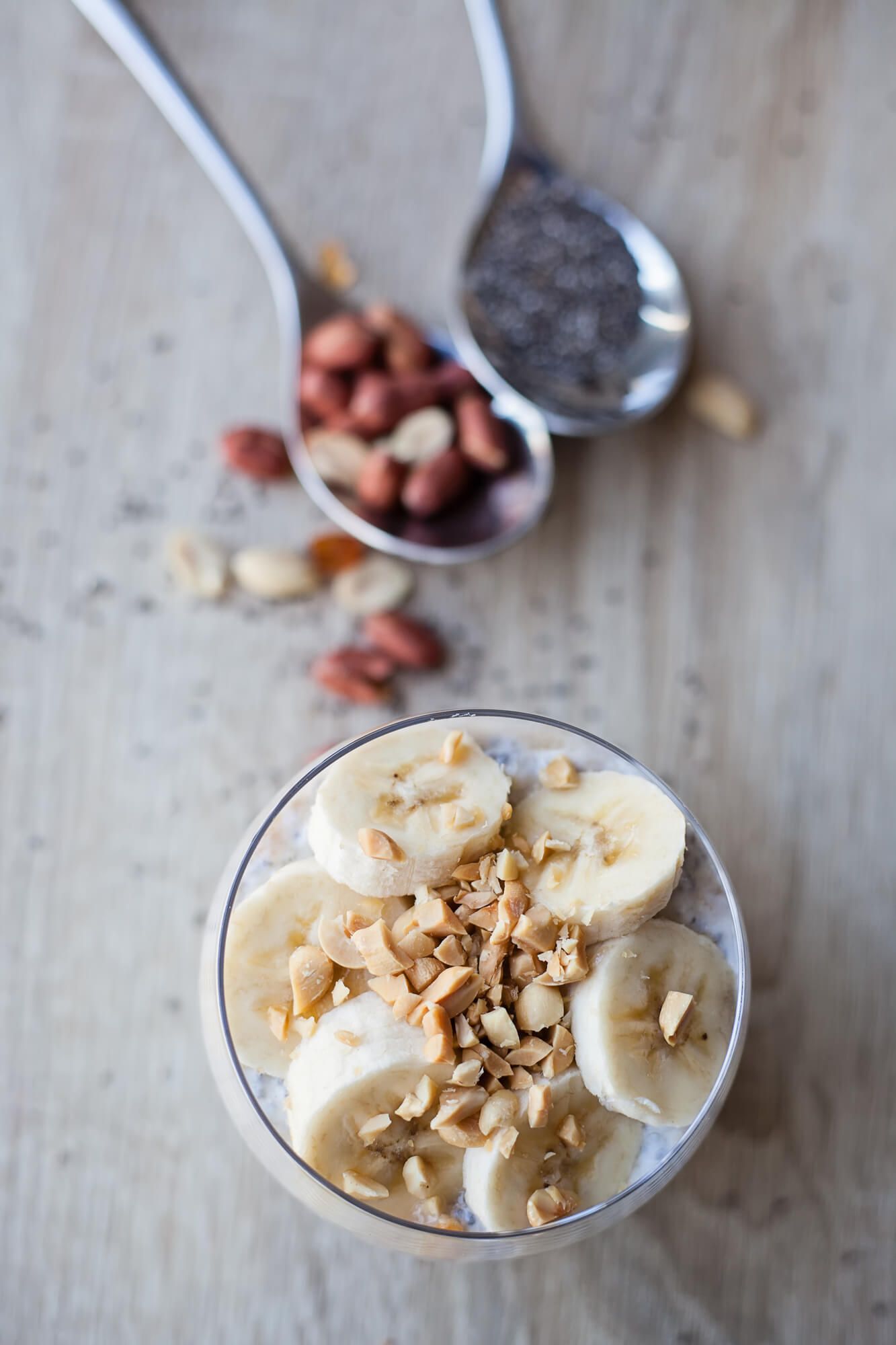 Banana chia seed pudding in a glass jar with banana slices and a spoon.