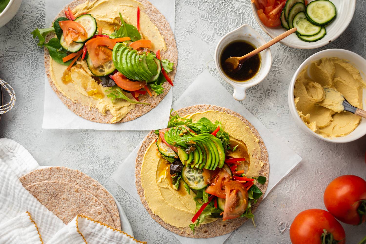 Hummus and vegetable wraps with tomato, lettuce, cucumbers, and balsamic vinegar.