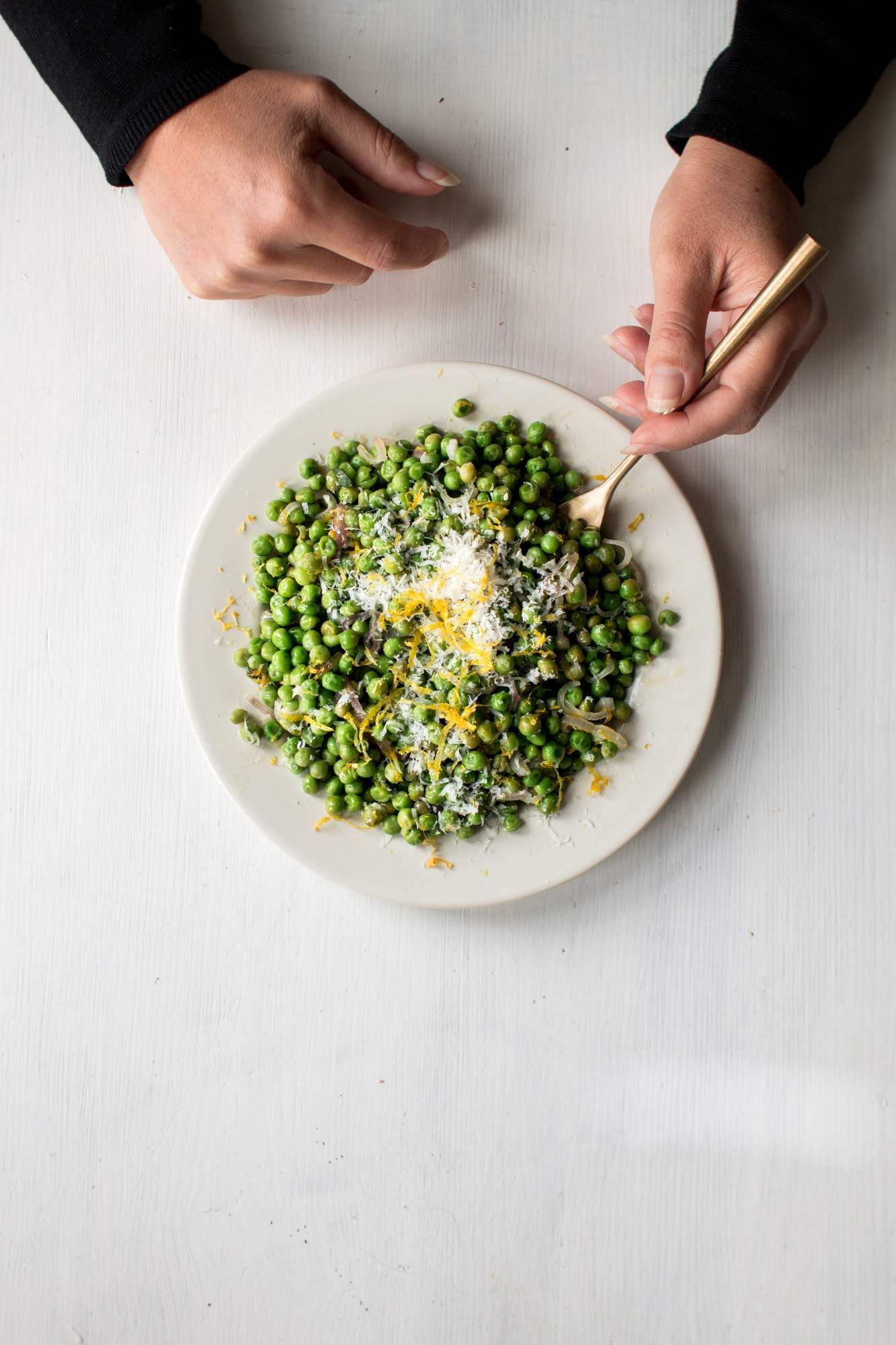 Frozen pas cooked in butter and garlic on a plate being held by two hands.