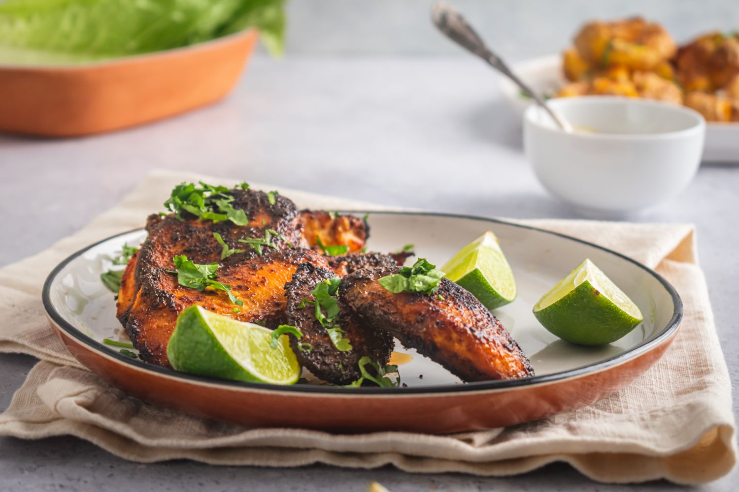 Baked blackened chicken breast pieces with paprika and spices served in a plate.