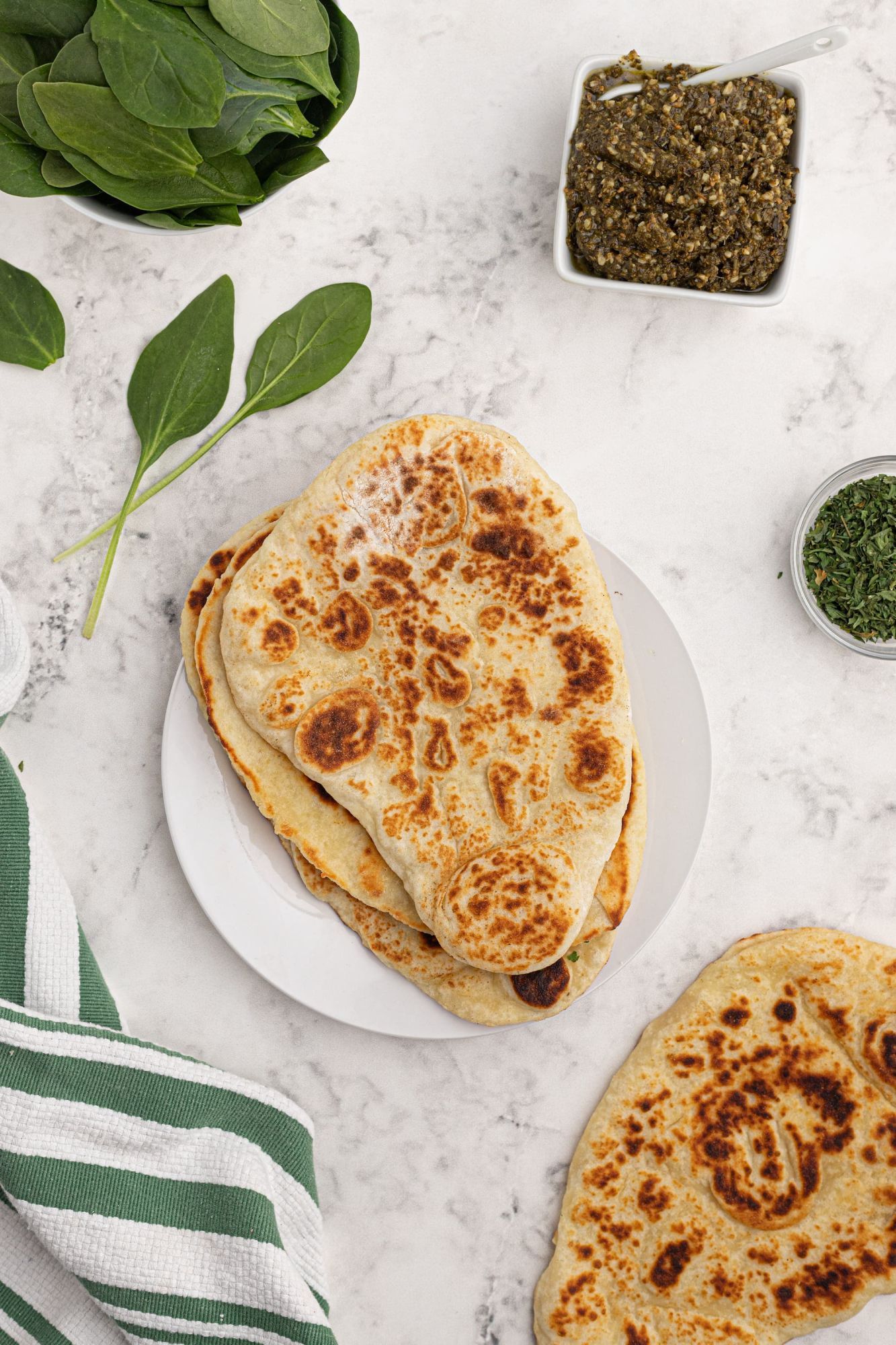 Homemade two ingredient Naan bread with spinach and chutney on the side.