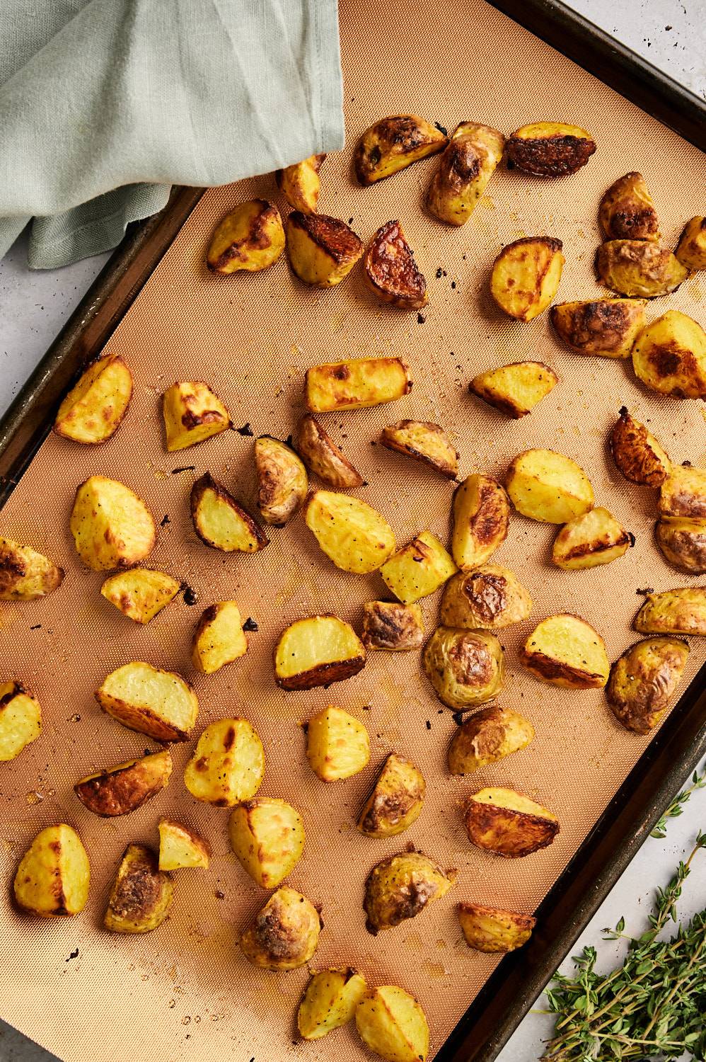 Oven roasted potatoes on a baking sheet with browed, crispy edges.