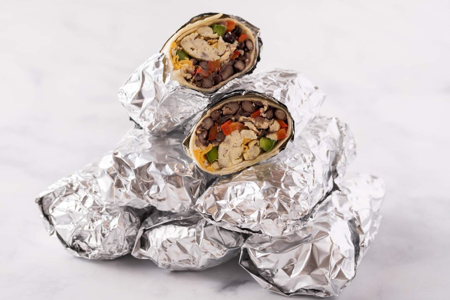 Freezer burritos wrapped in aluminum foil.