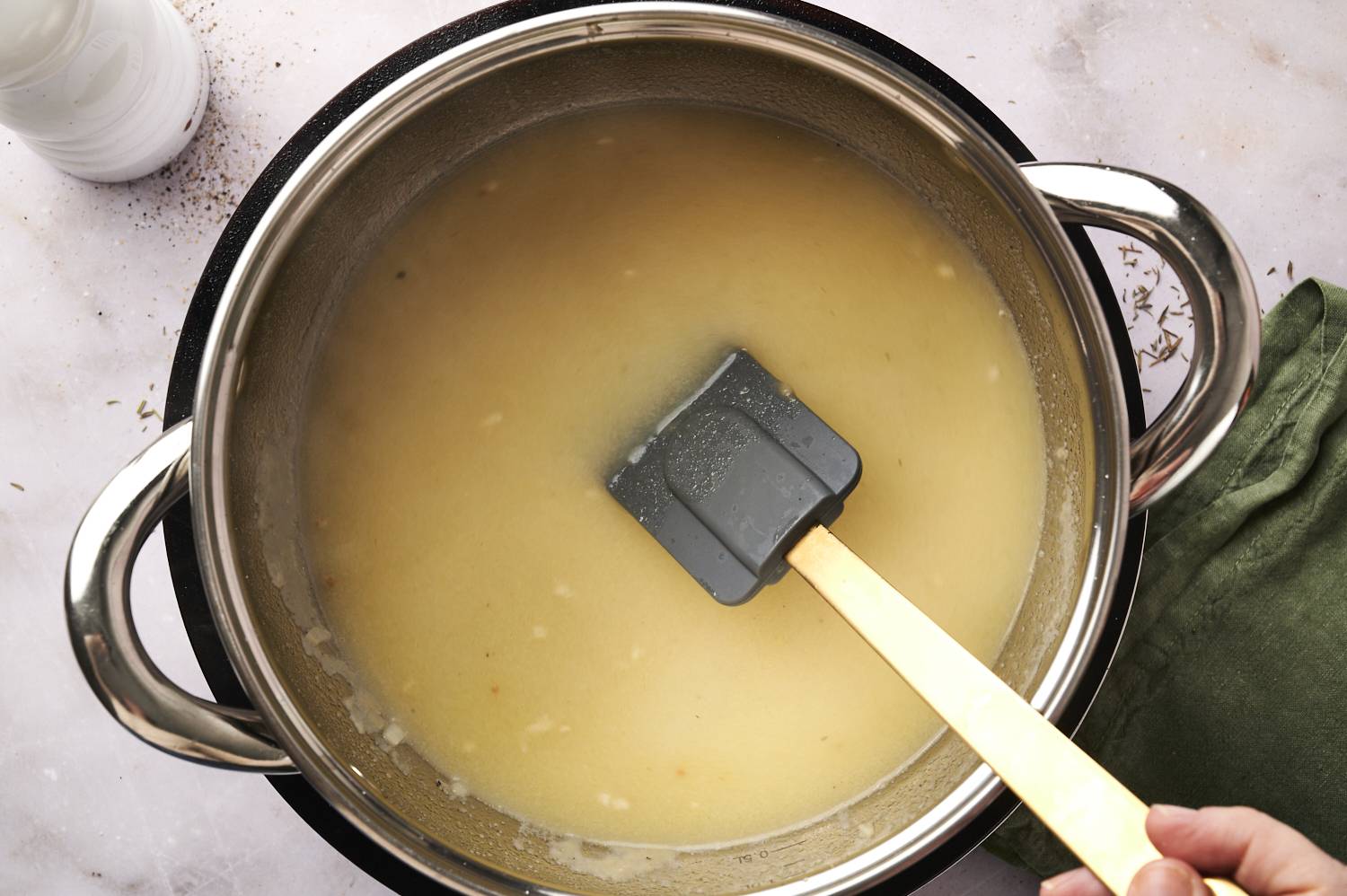 Gravy being stirred in pot.