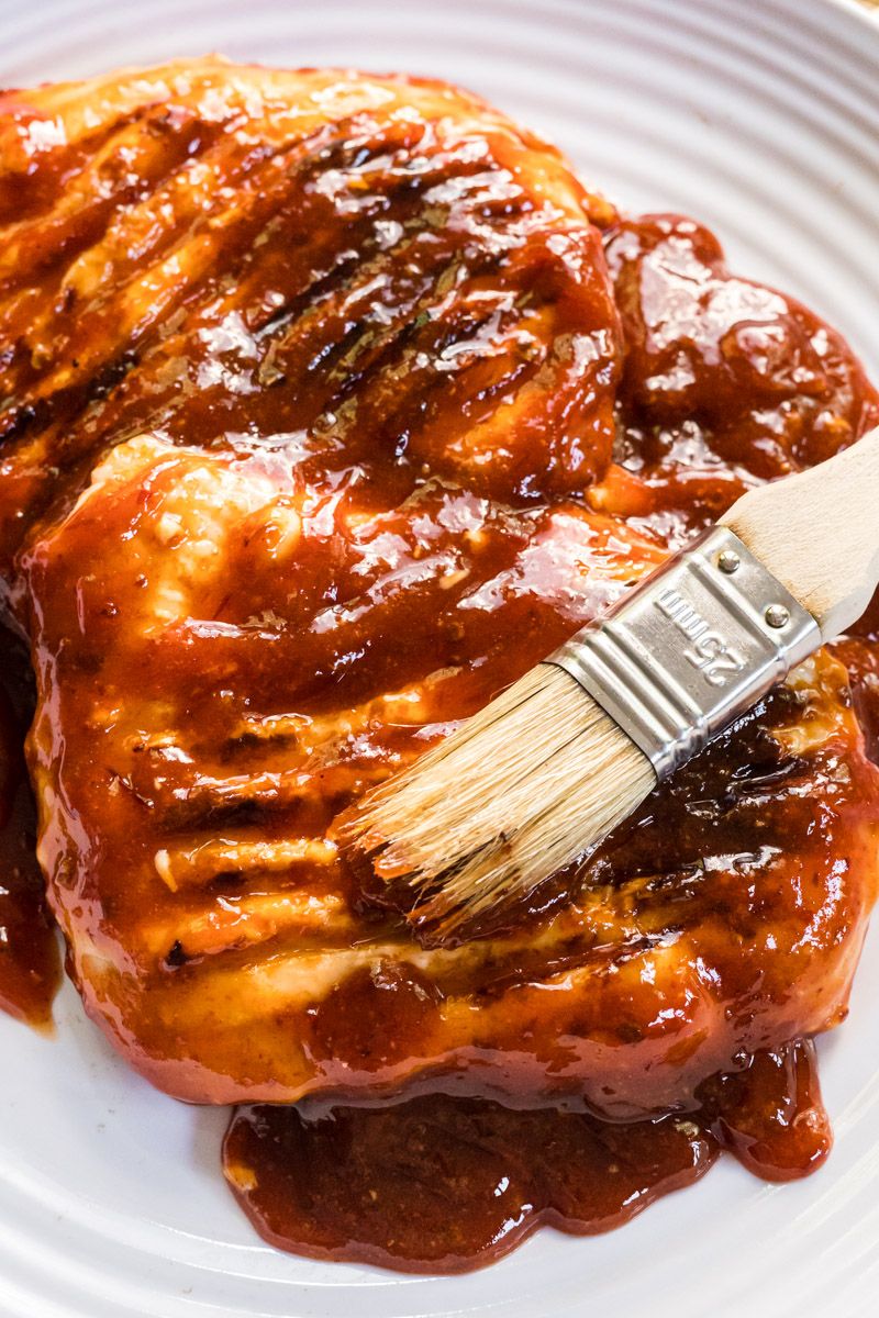 Grilled chicken breast with honey chipotle sauce on a plate with a brush.