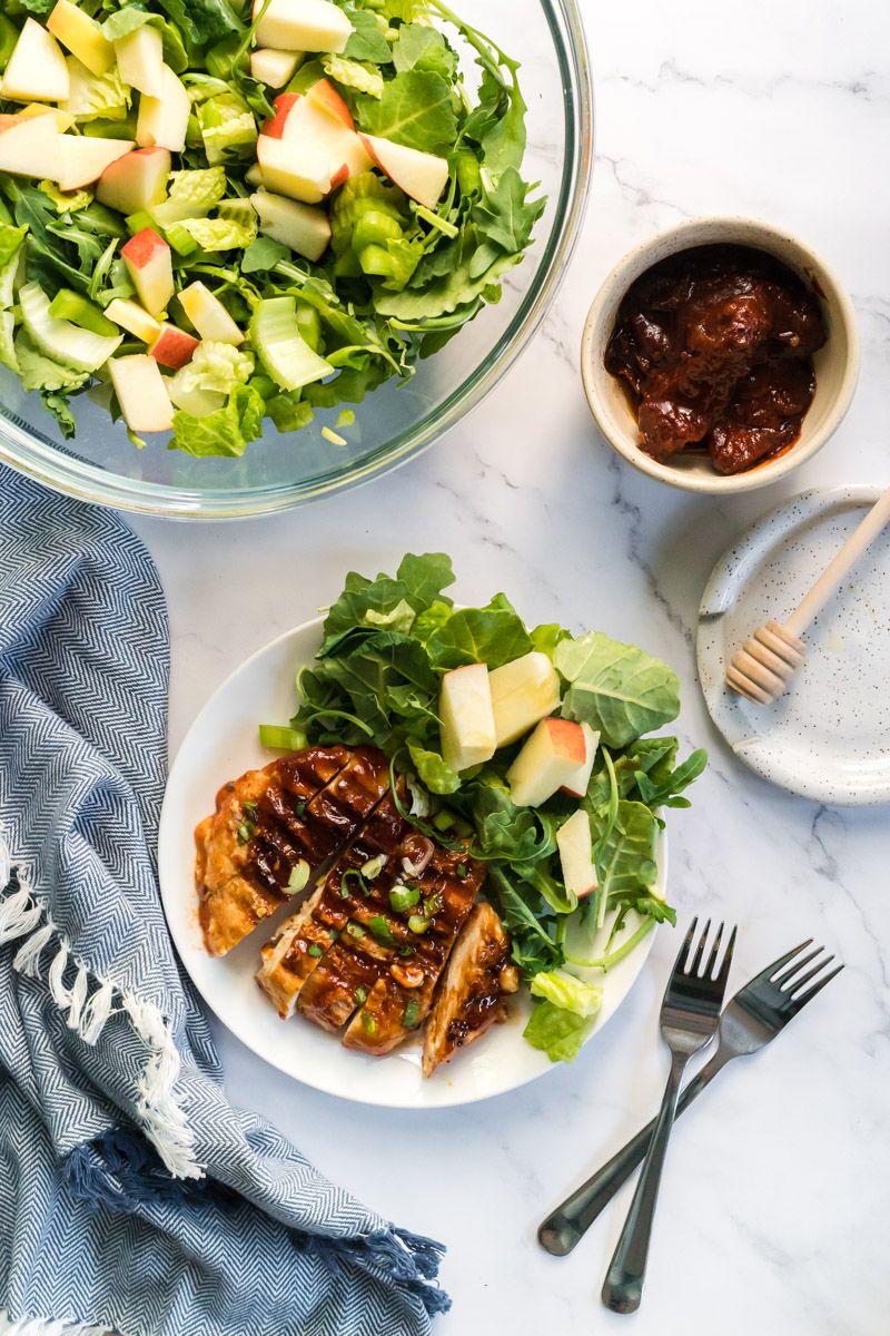 Grilled honey chipotle chicken served with a green salad and apples.