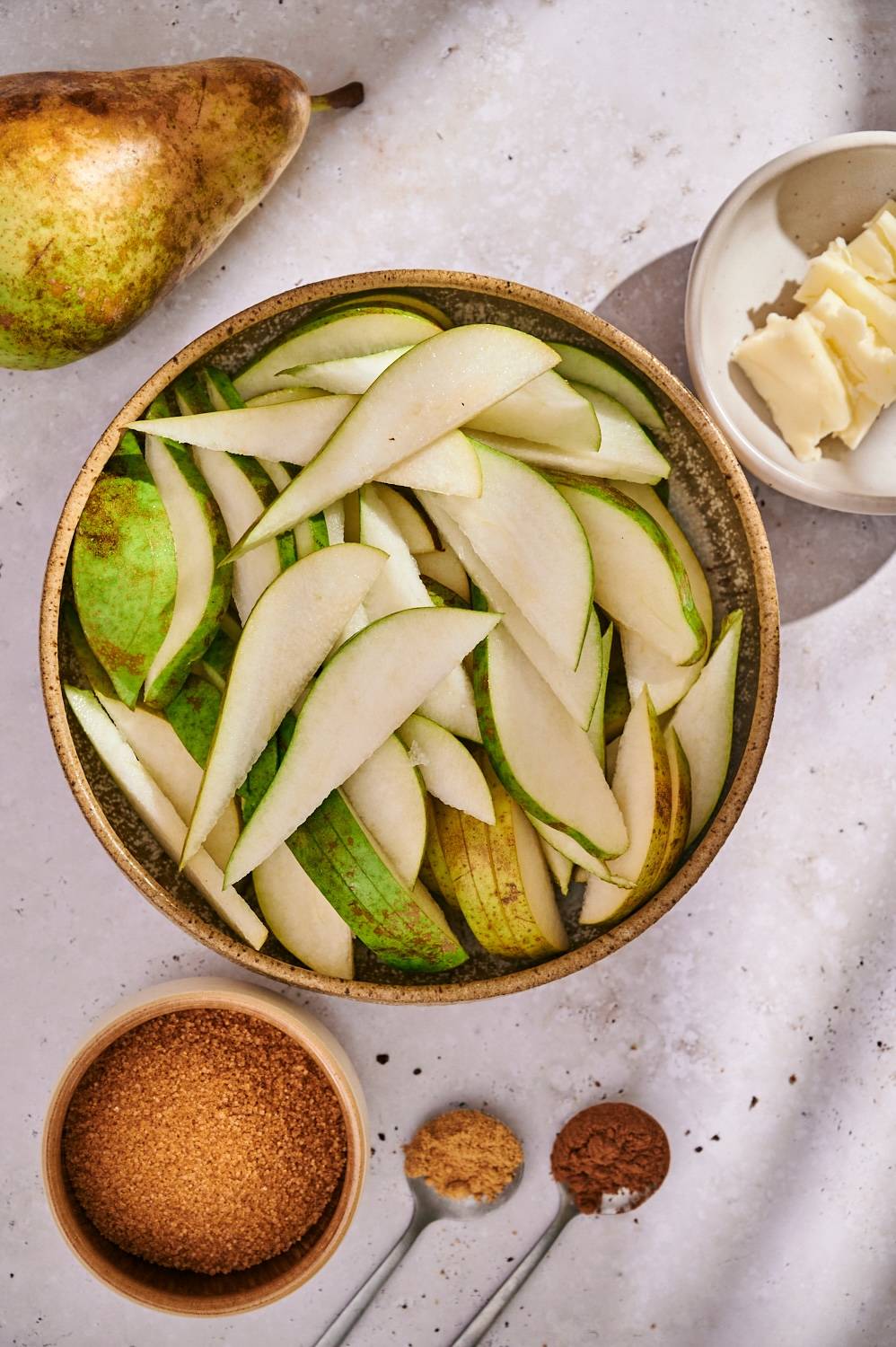 Ingredients for grilled pears including whole pears, butter, brown sugar, cinnamon, and ginger.