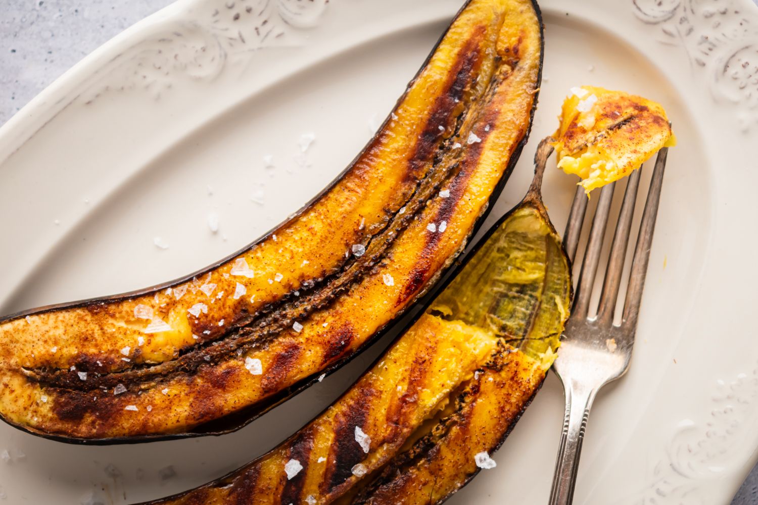 Grilled mature plantains with cinnamon served in a plate.