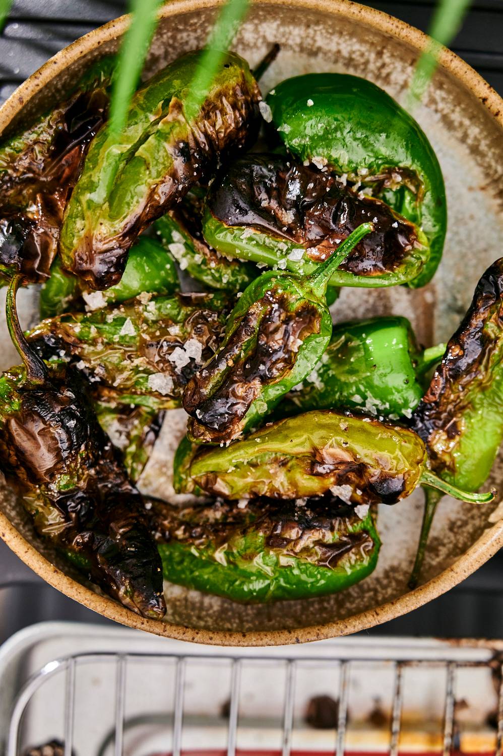 Bowl of grilled shishito peppers and flaky sea salt. 