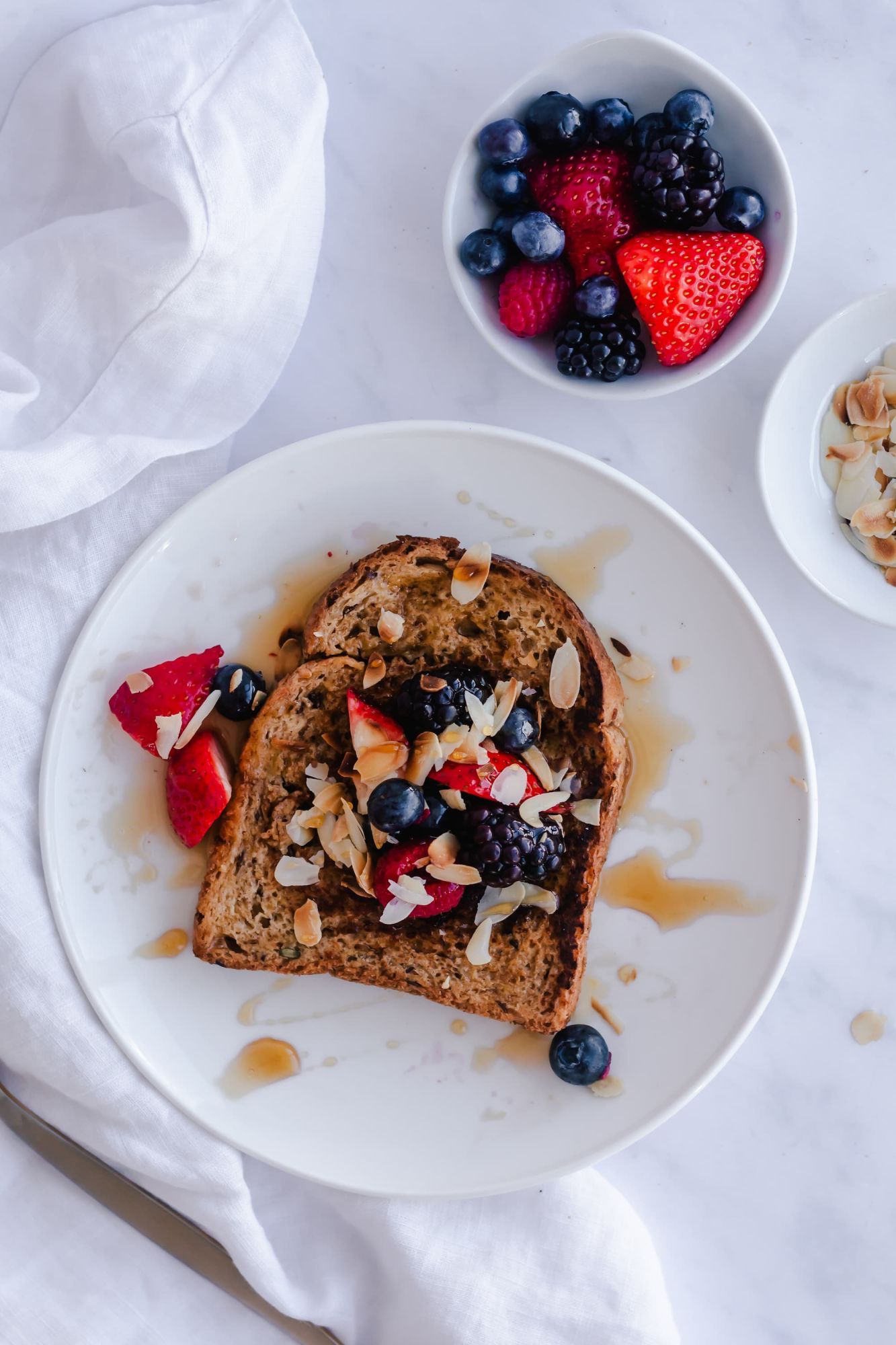 Whole grain French toast drizzled with maple syrup and topped with fresh berries.