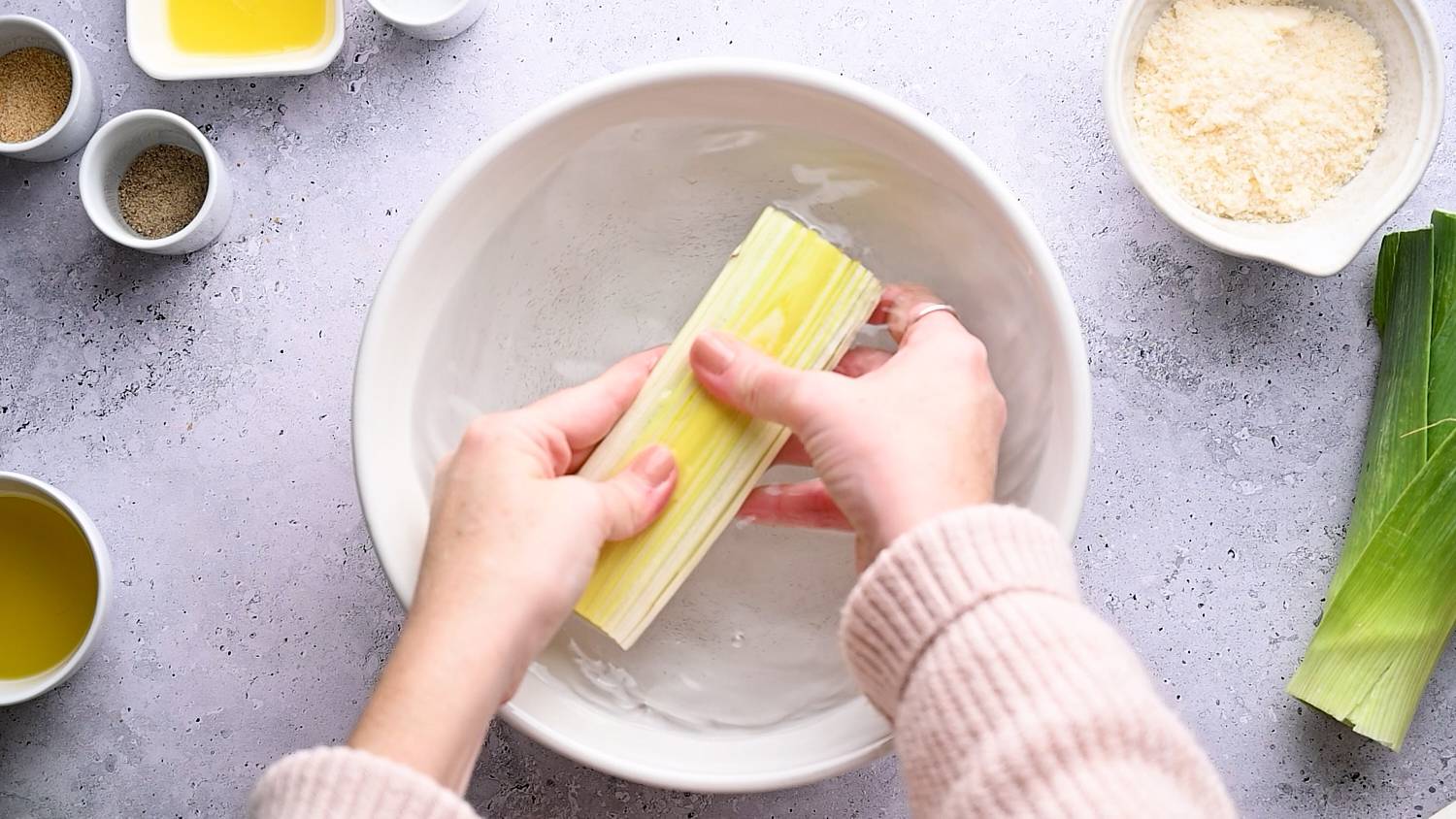 Leeks being washed in a bowl of water.