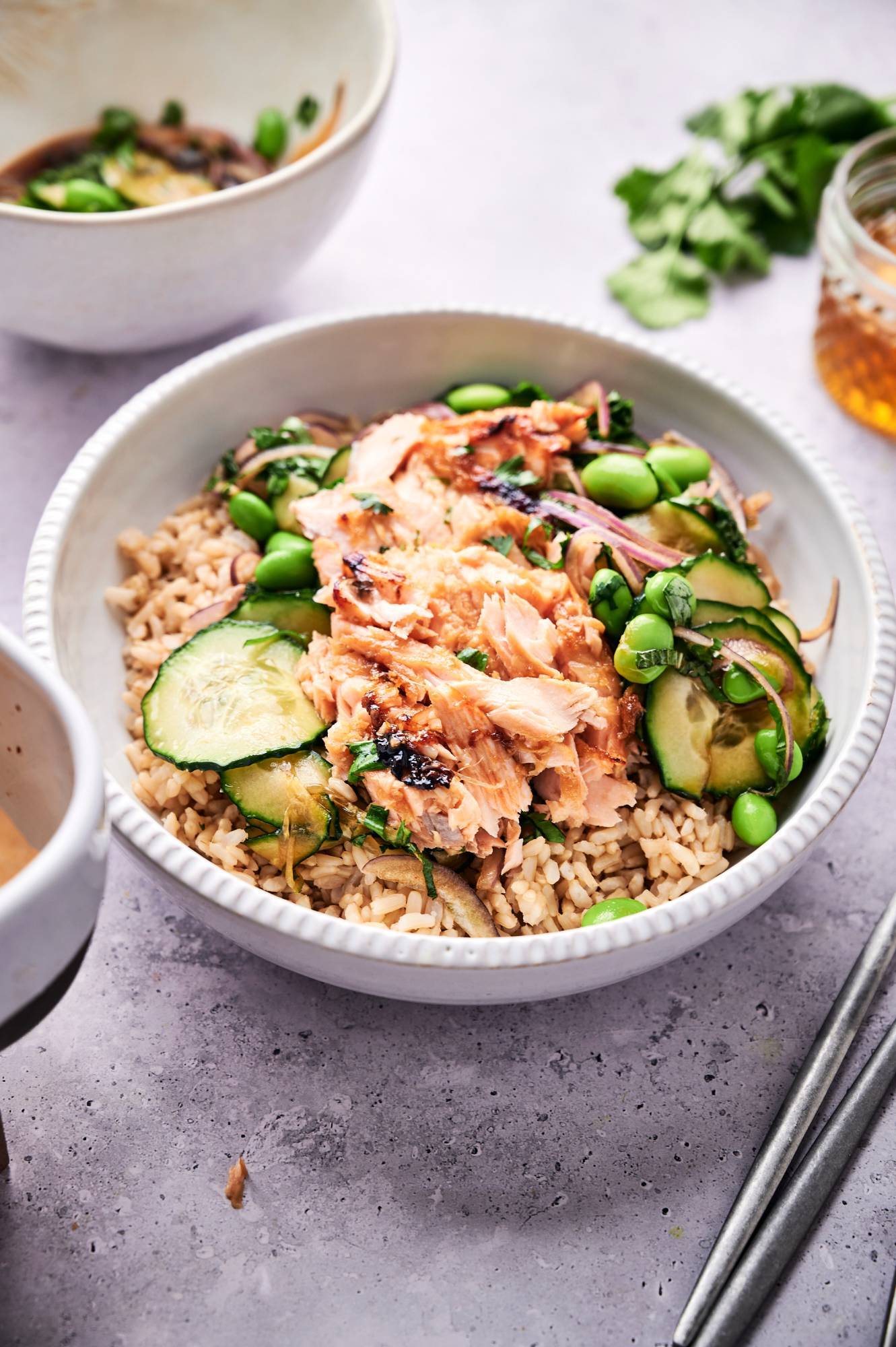 Asian salmon and rice bowls served with cucumbers, edamame, red onion, and a quick soy dressing.