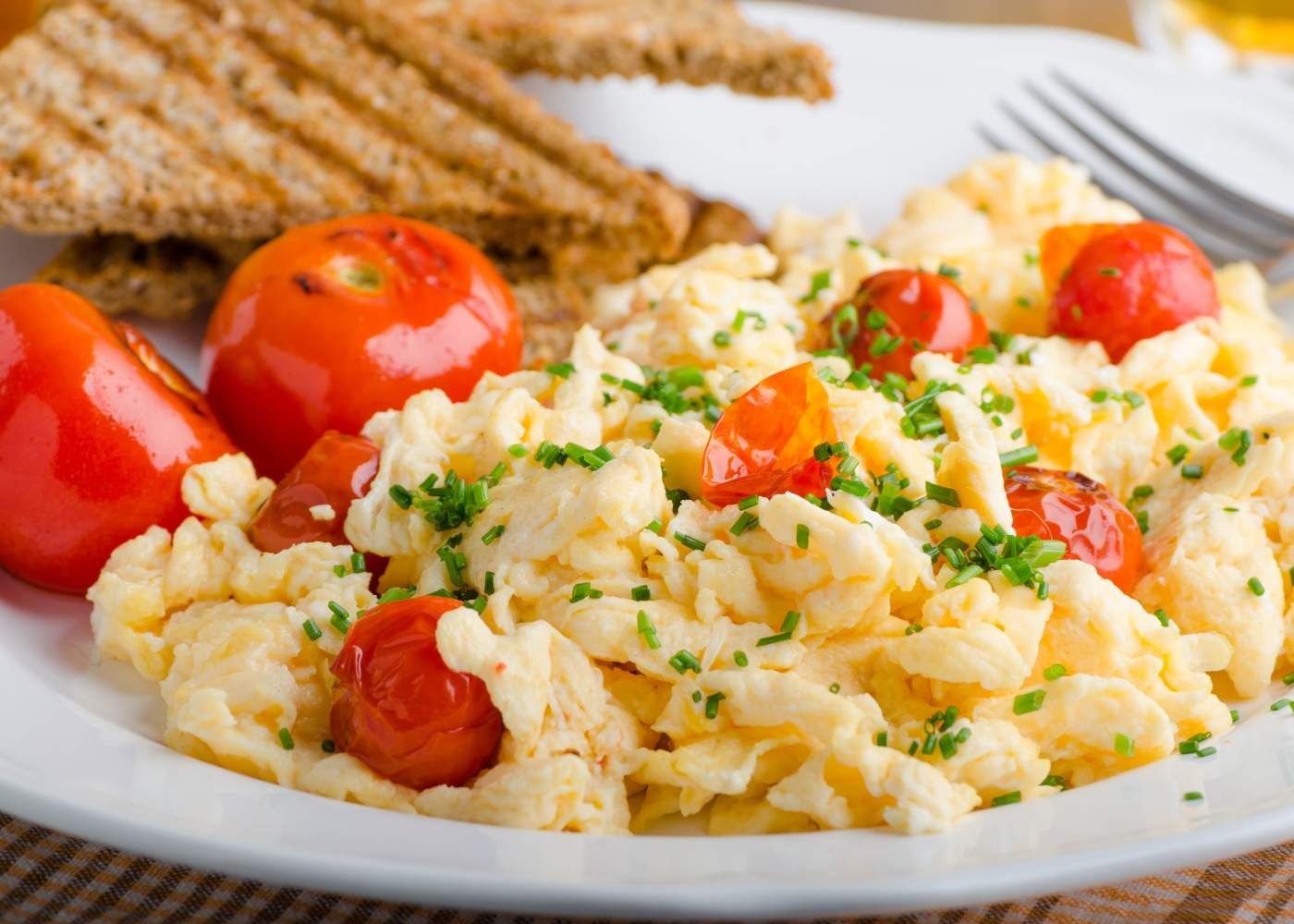 Scrambled Eggs with tomatoes and toast.