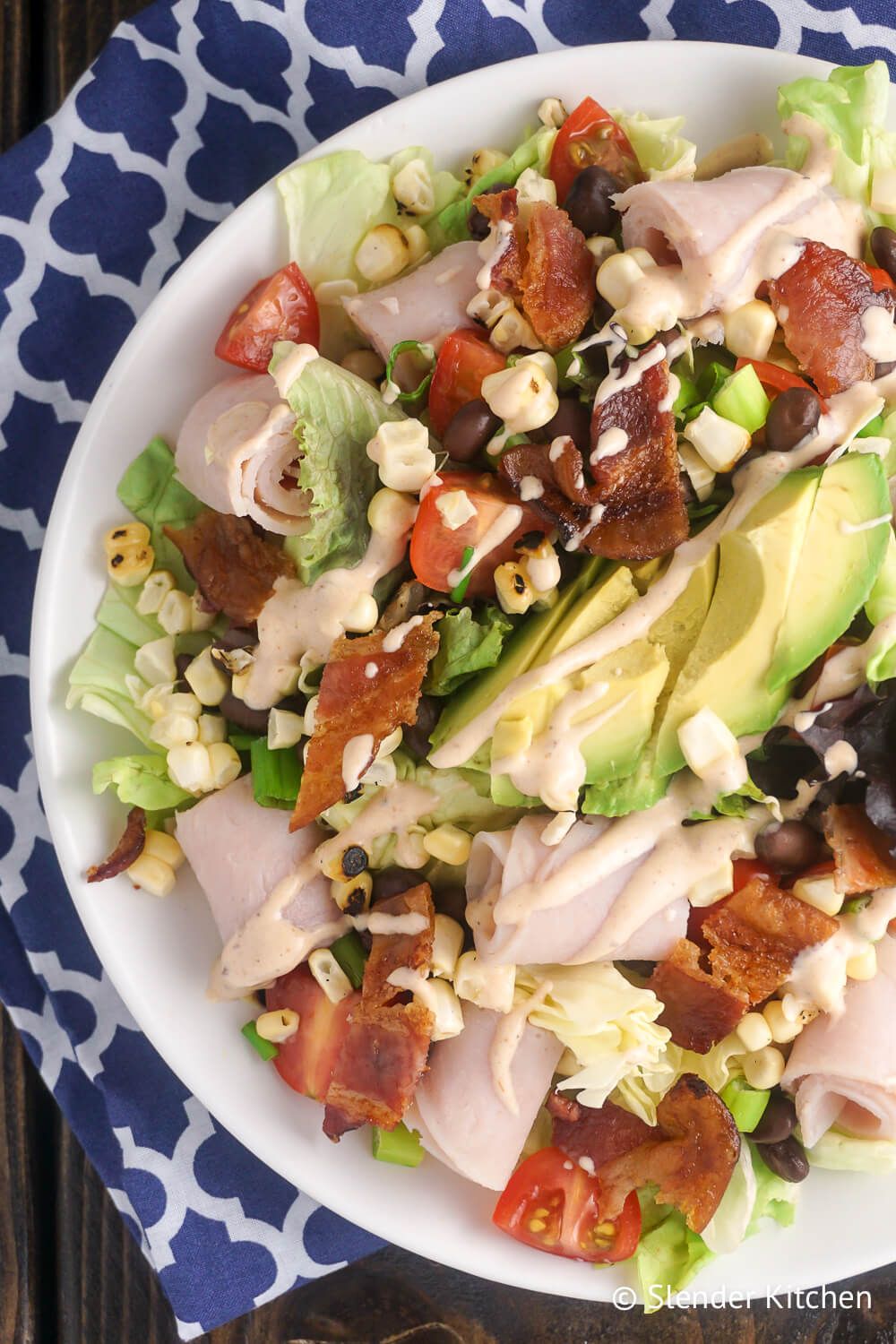 Turkey salad with avocado, bacon, corn, and black beans in a bowl.