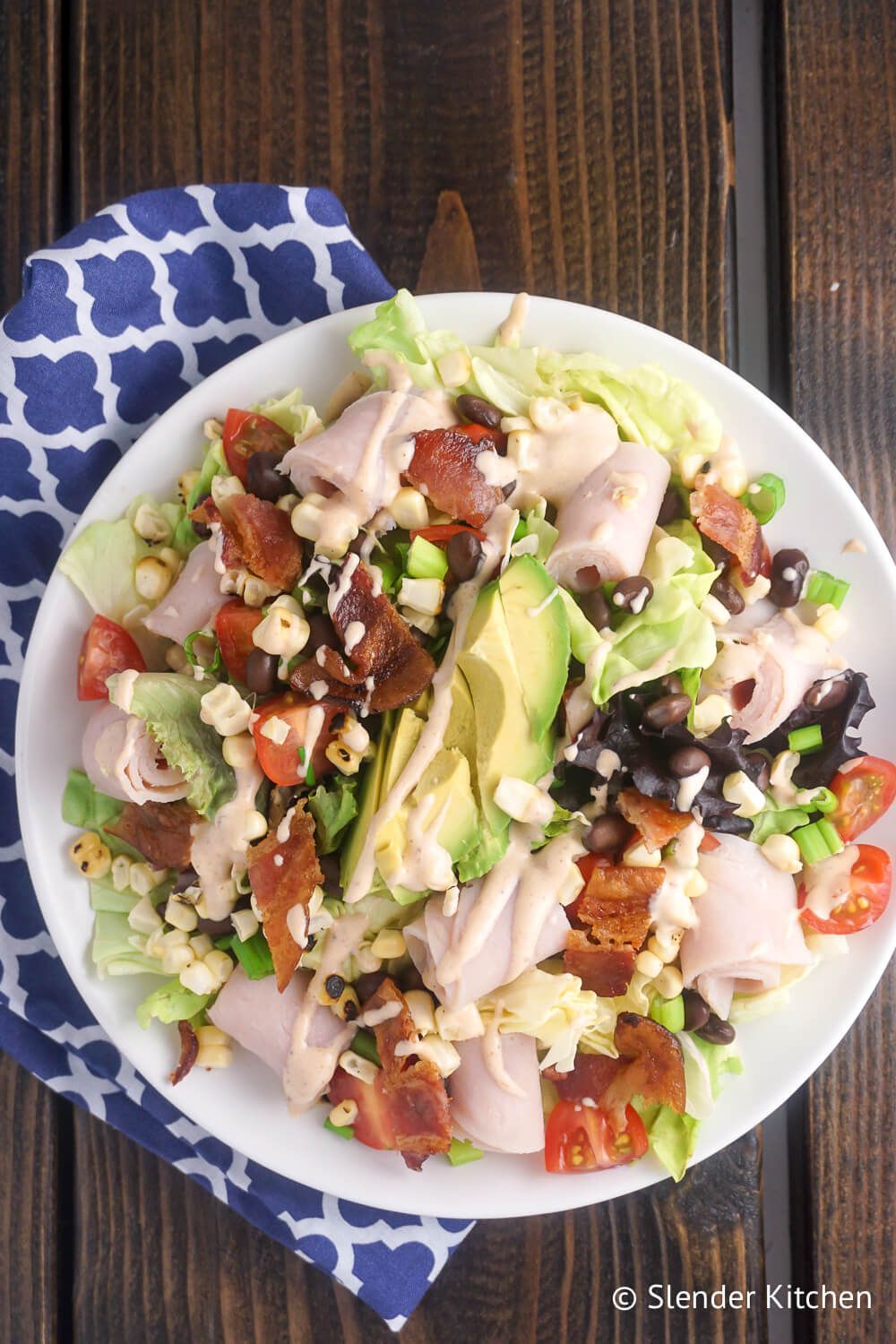 Southwestern Turkey BLTA salad in a bowl on a wooden table.