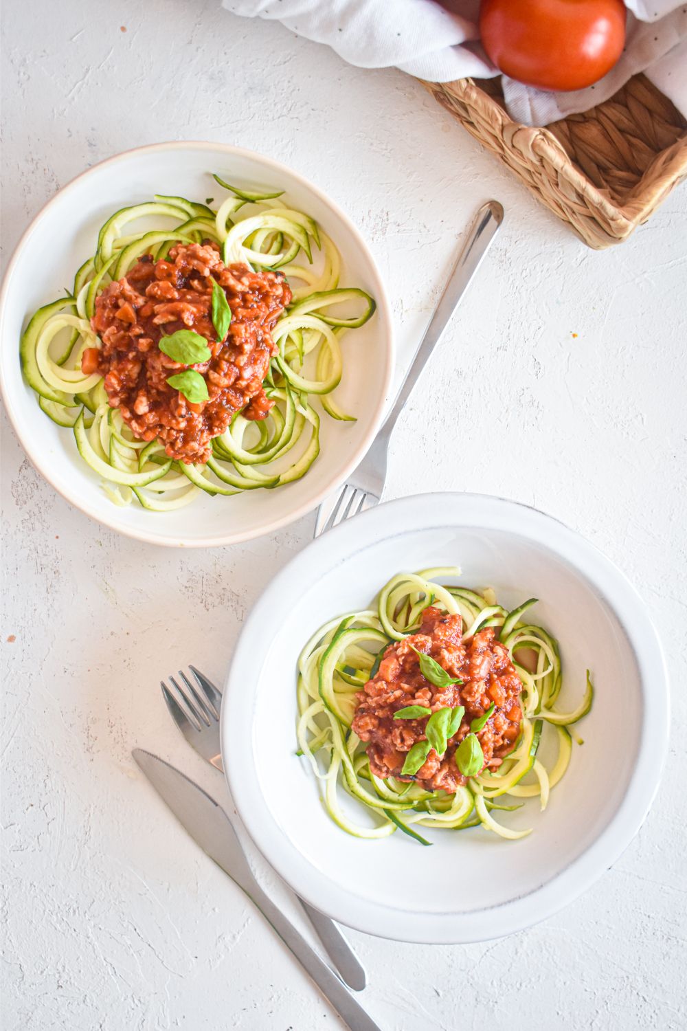 Bolognese with zucchini noodles and ground turkey on a plate with basil.