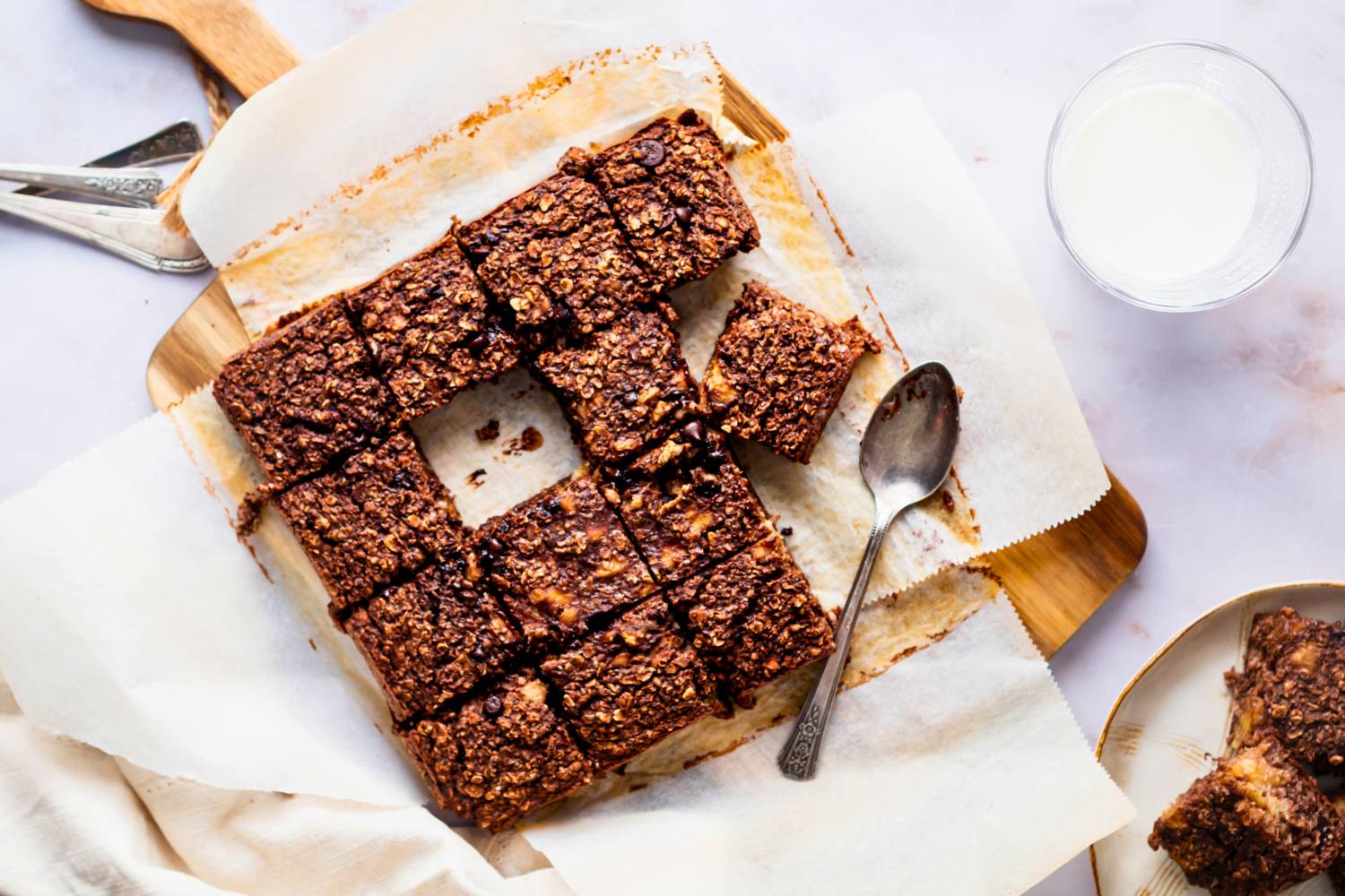 Baked chocolate oatmeal for breakfast cut into squares on a cutting board.
