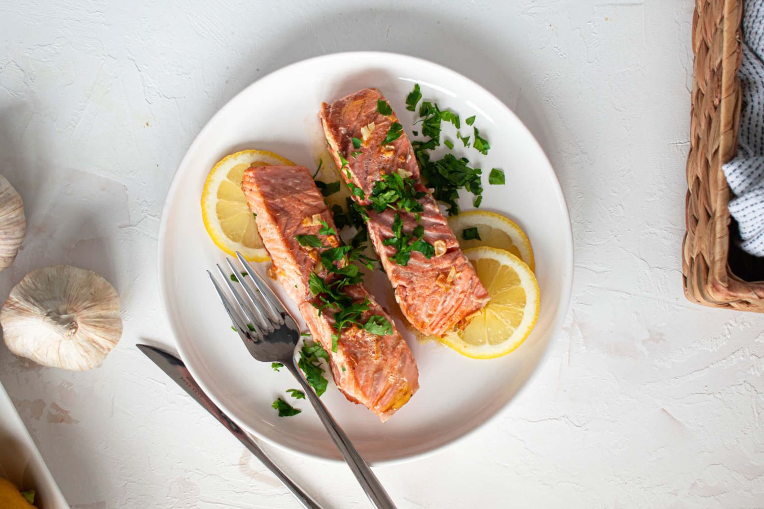 Dijon baked salmon served on a white plate with lemon slices and parsley.