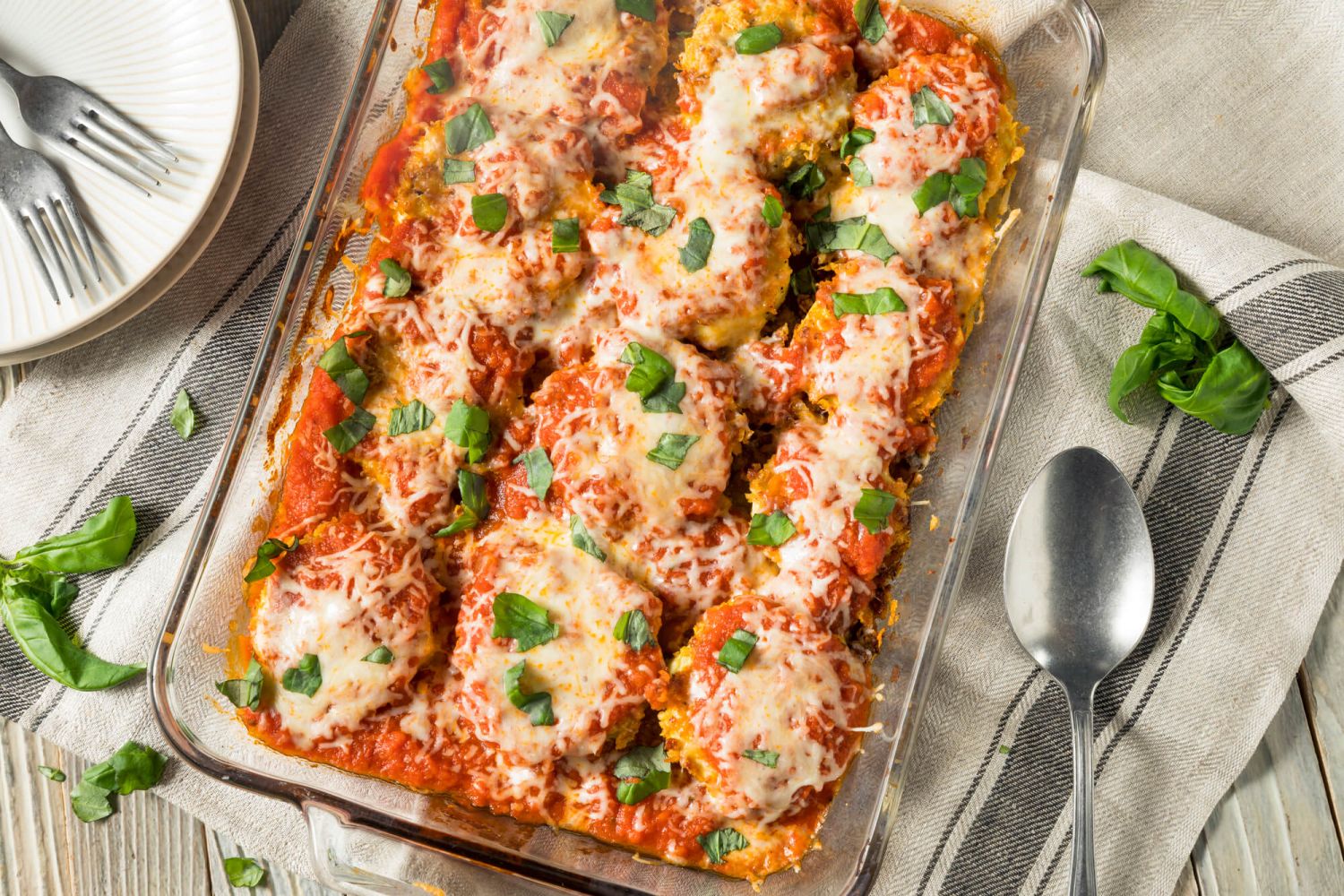 Eggplant parmesan recipe in a baking dish with fork on the side.