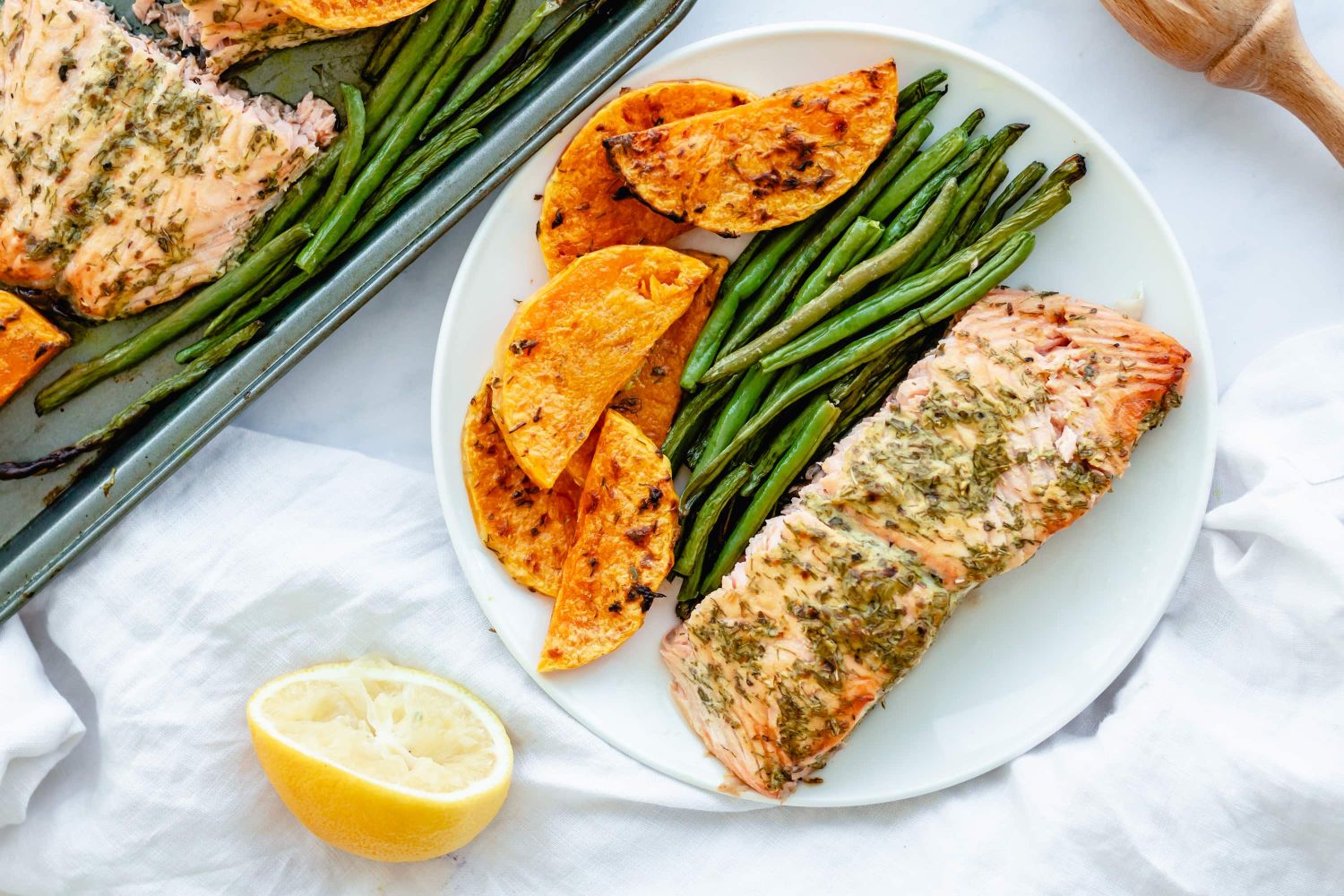 Roasted salmon on a plate with green beans and butternut squash.