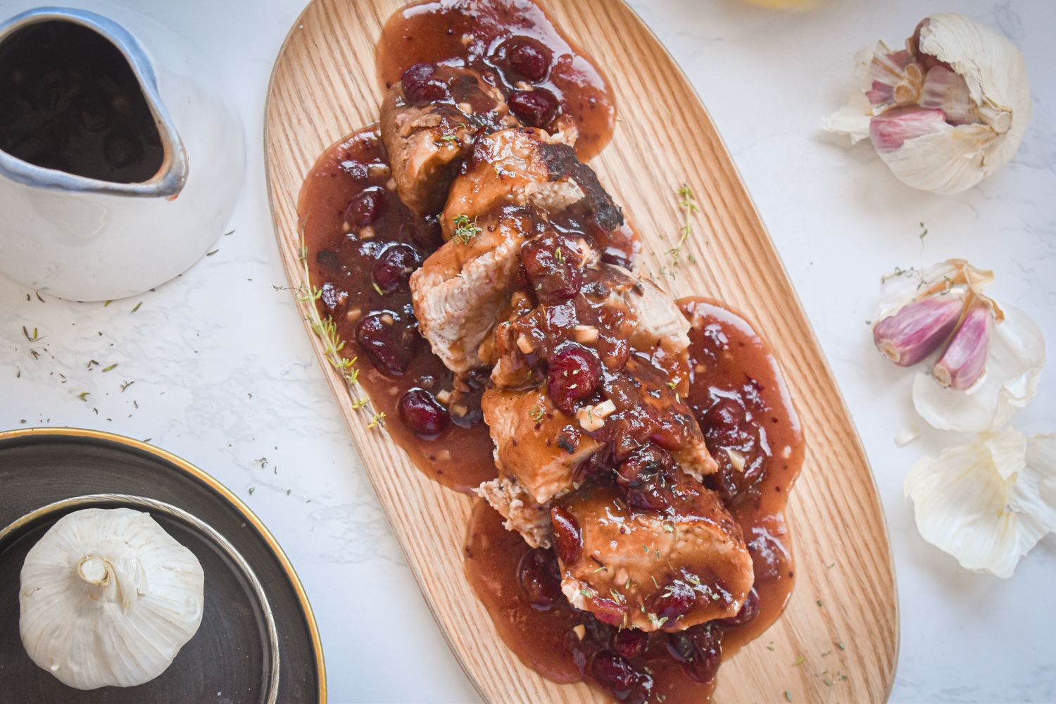 Crockpot cranberry pork tenderloin sliced and served on a blue plate with extra cranberry sauce.