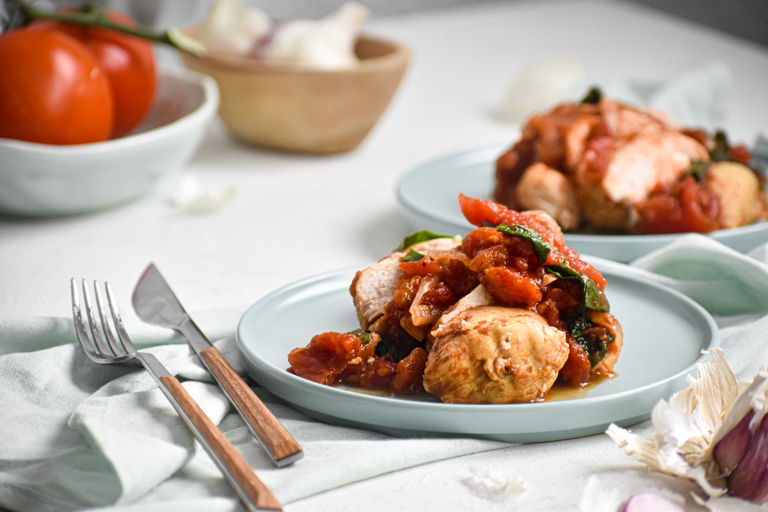 Slow cooker tomato balsamic chicken breast with spinach that is sliced and served on a plate.