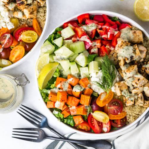 Mediterranean Bowls with chicken, cucumbers, red peppers, feta cheese, sweet potatoes, and tahini dressing.