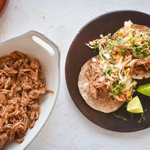 Slow Cooker Chorizo Spiced Pulled Pork in a corn tortilla with cabbage slaw.