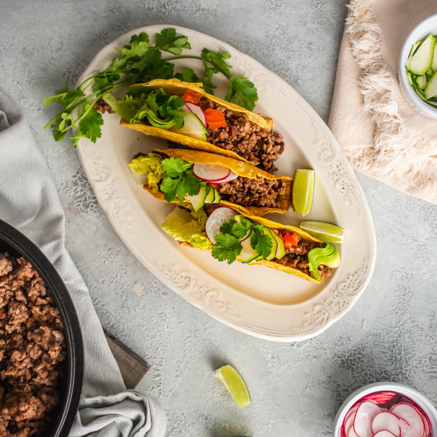 Ground beef tacos with ancho chili seasoning served in baked taco shells with lettuce, tomato, and cilantro.