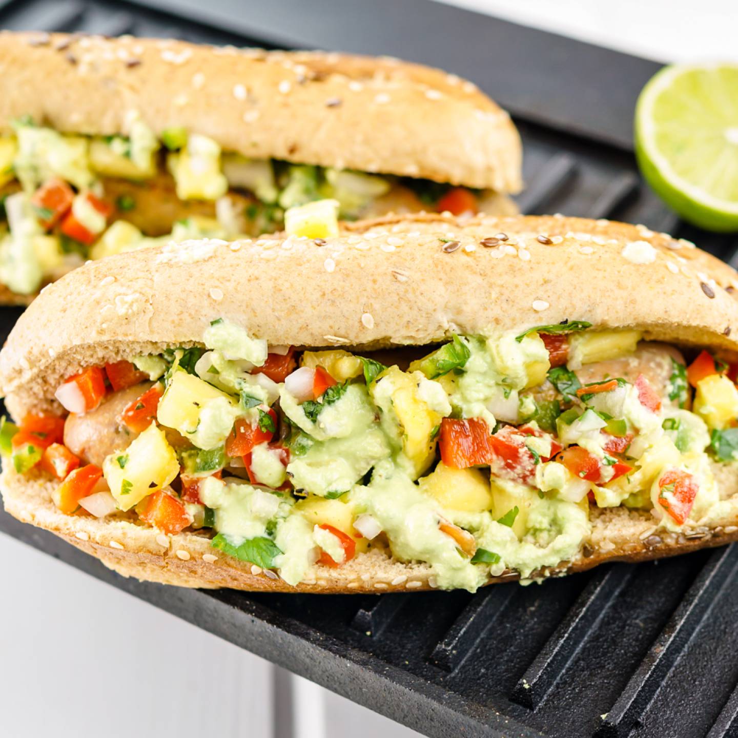 Pineapple chicken sausages in a whole wheat bun with salsa and green sauce.