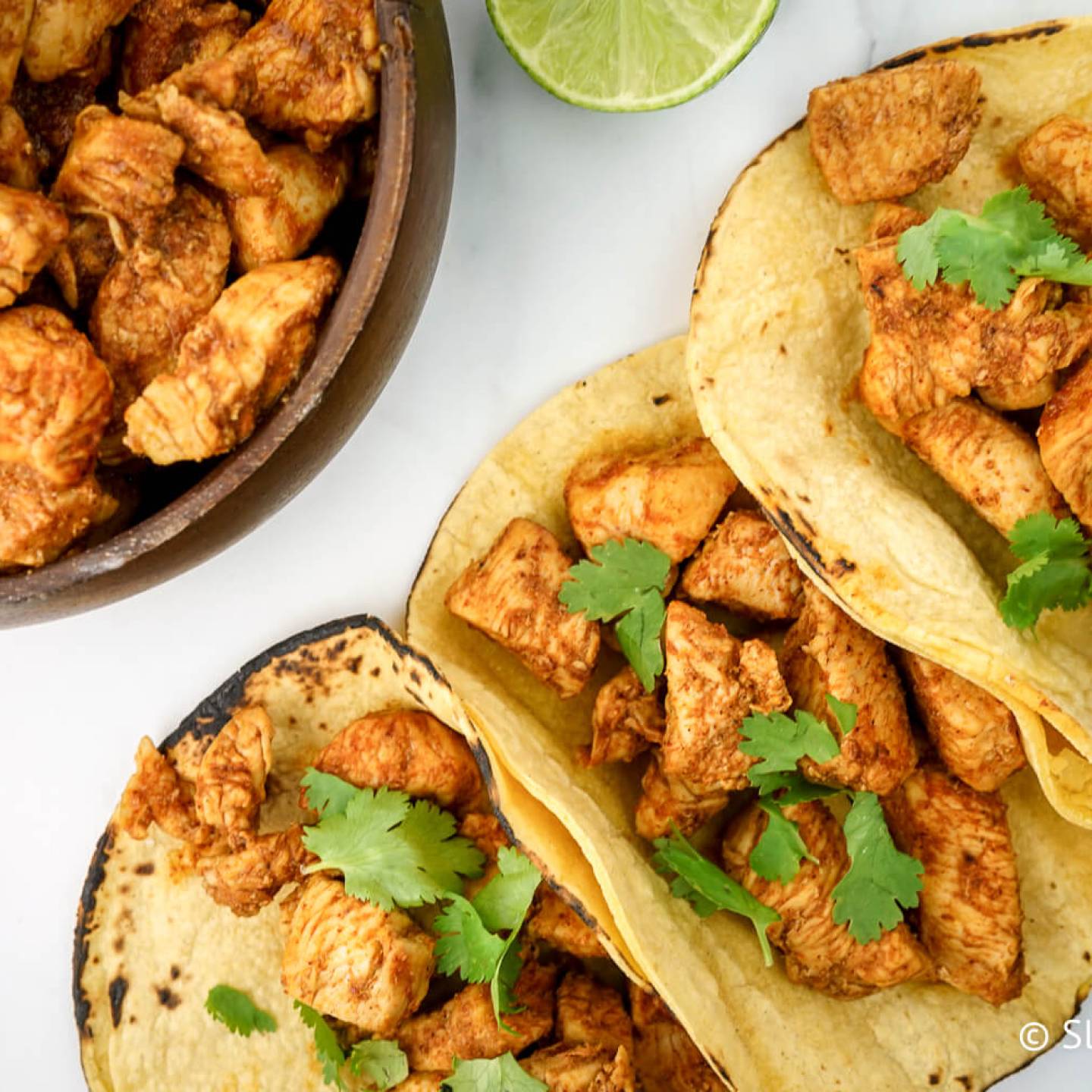 Chicken soft tacos with seasoned chicken breast and cilantro served on corn tortillas. 