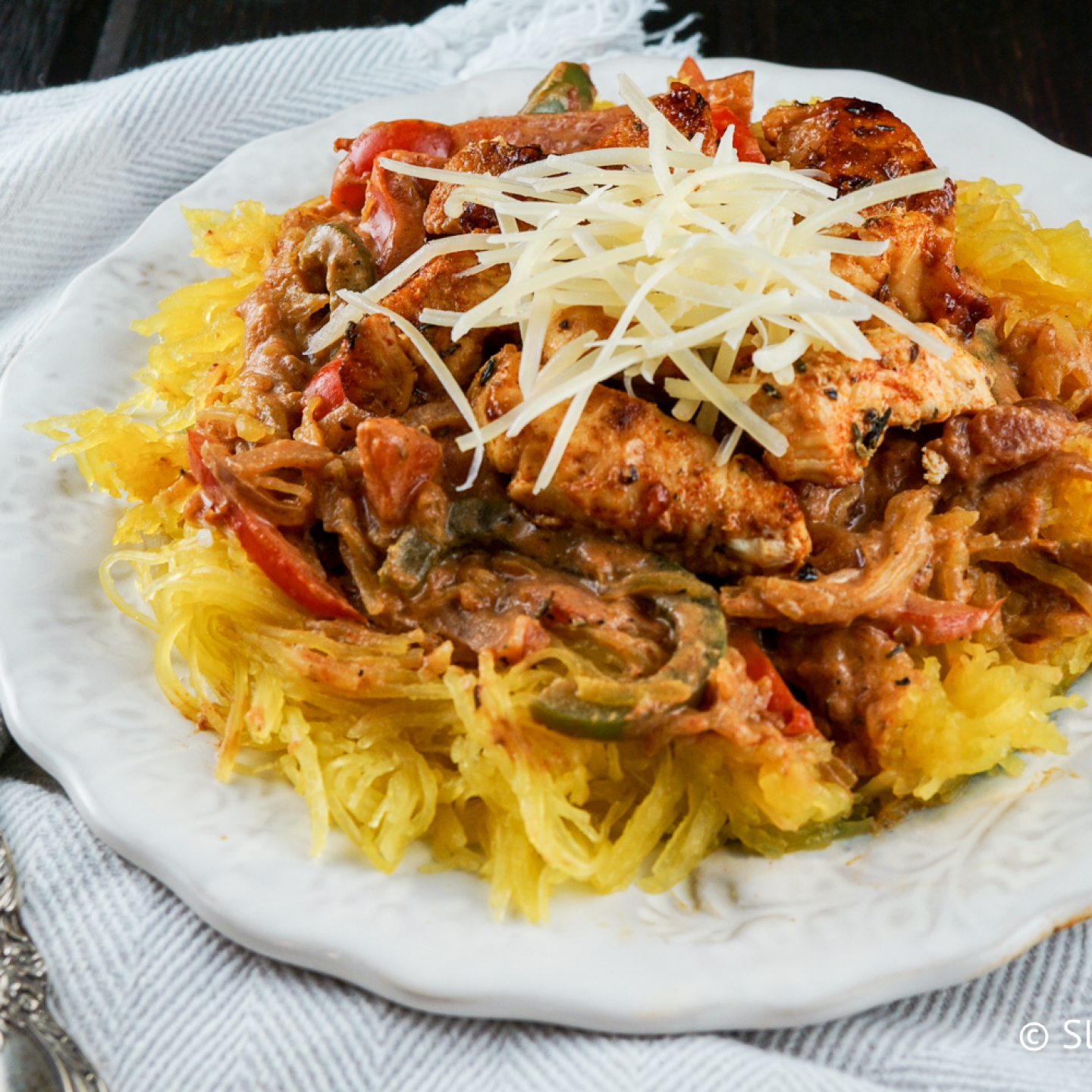 Cajun chicken spaghetti squash with peppers, chicken breast, a creamy tomato sauce, and spaghetti squash.