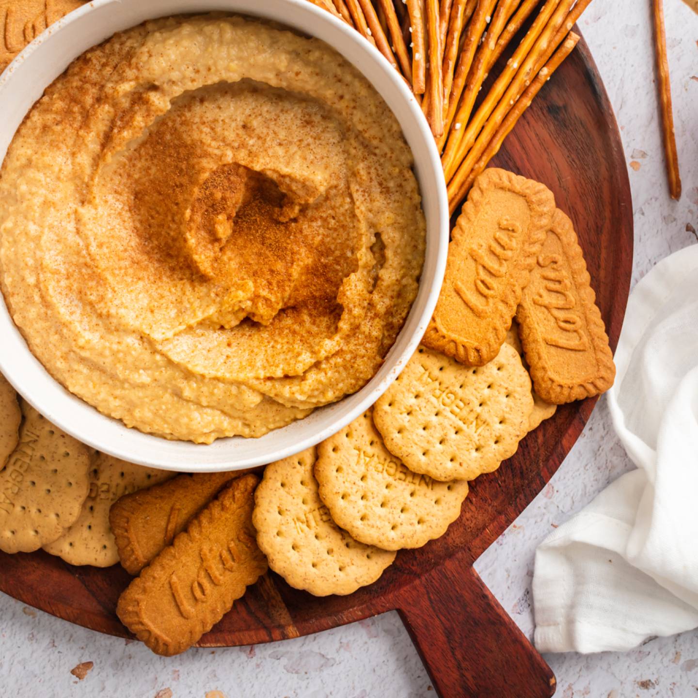 Dessert hummus with chickpeas, cinnamon, maple syrup, almond butter, and dates blended and served with pretzels and graham crackers.