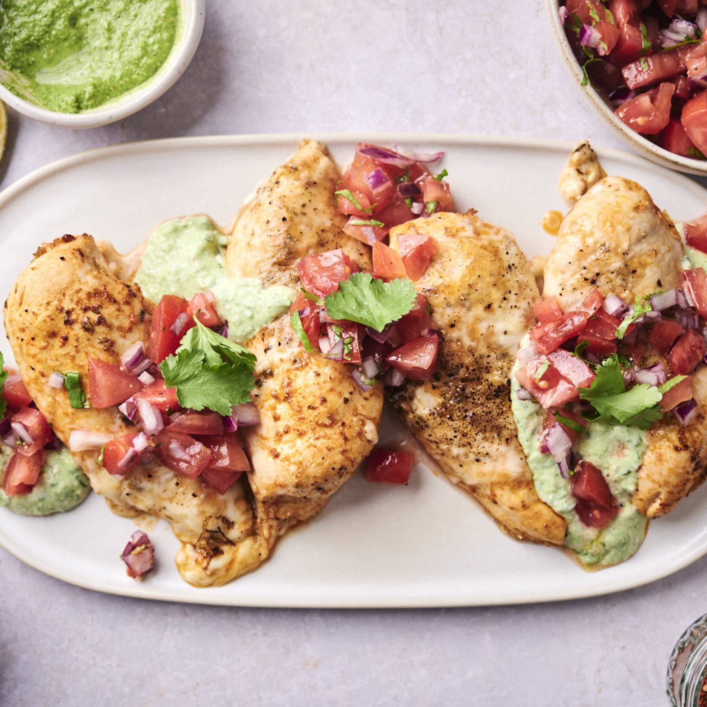 Fiesta lime chicken served on a plate with melted pepper jack cheese, pico de gallo, and creamy cilantro ranch dressing.