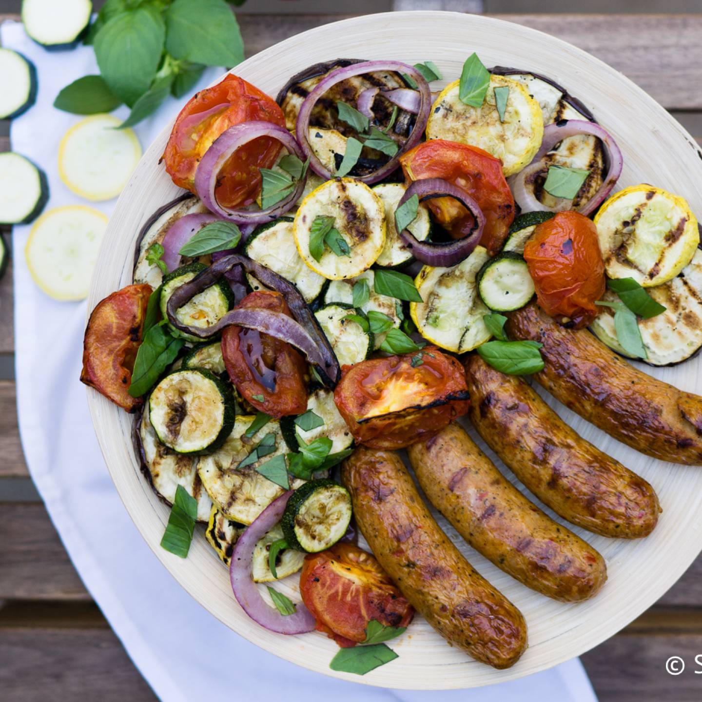 Grilled chicken sausage with vegetables on a plate.