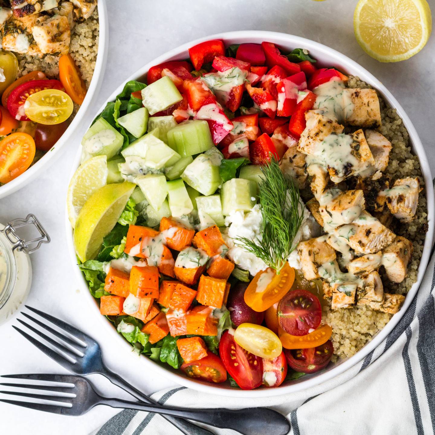 Mediterranean Bowls with chicken, cucumbers, red peppers, feta cheese, sweet potatoes, and tahini dressing.