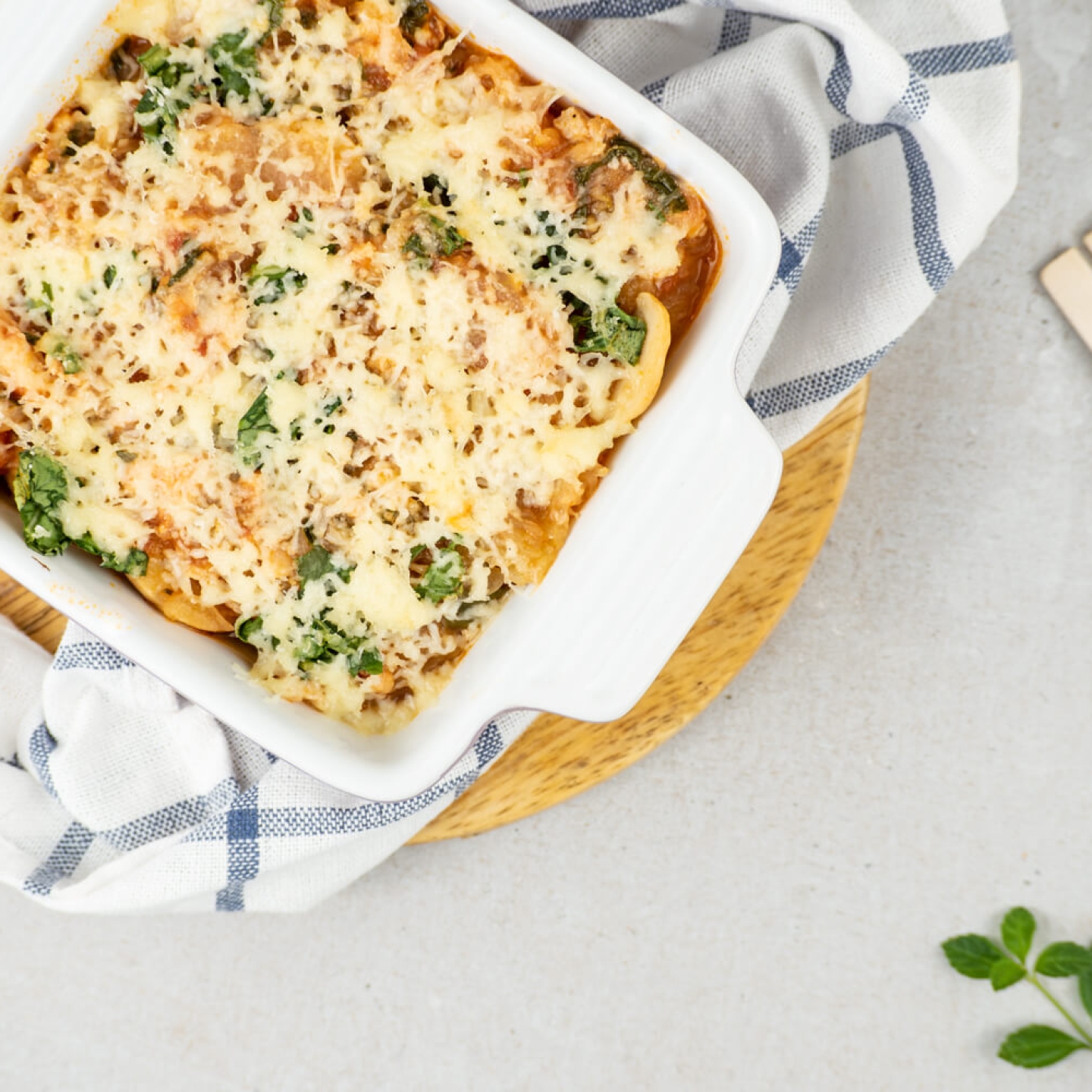 Mediterranean Turkey Spaghetti Squash with spinach, tomatoes, lean ground turkey, and melted cheese in a casserole dish.