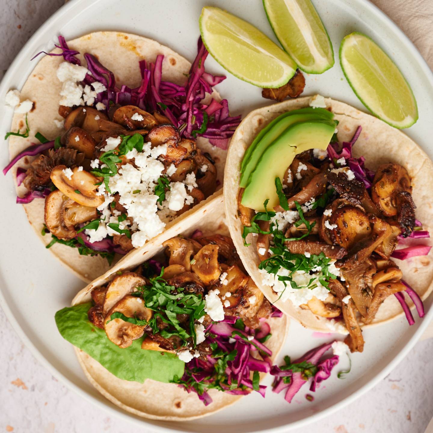 Mushroom tacos with crispy mushrooms, red cabbage slaw, queso fresco, and avocado on corn tortillas.