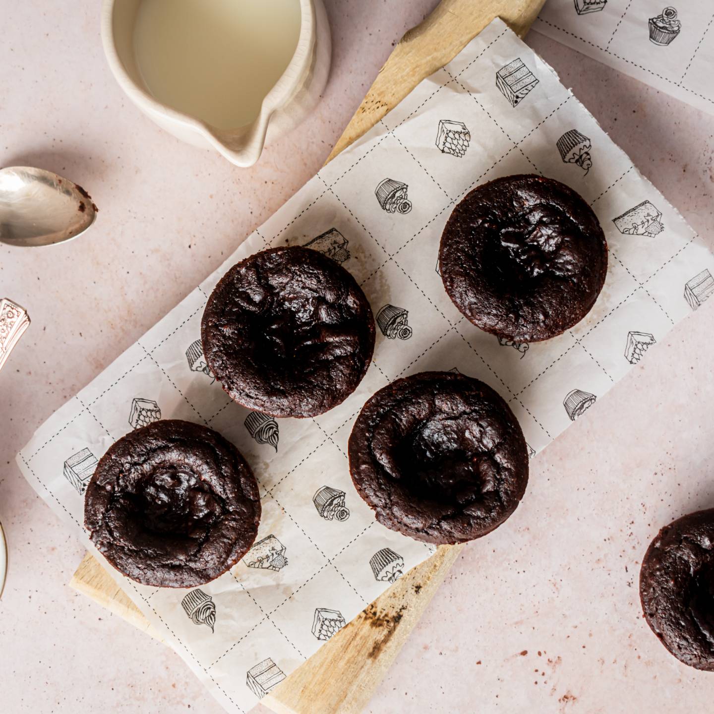 Flourless Pumpkin Brownie Bites with canned pumpkin and almond butter on a wooden cutting board with maple syrup on the side.