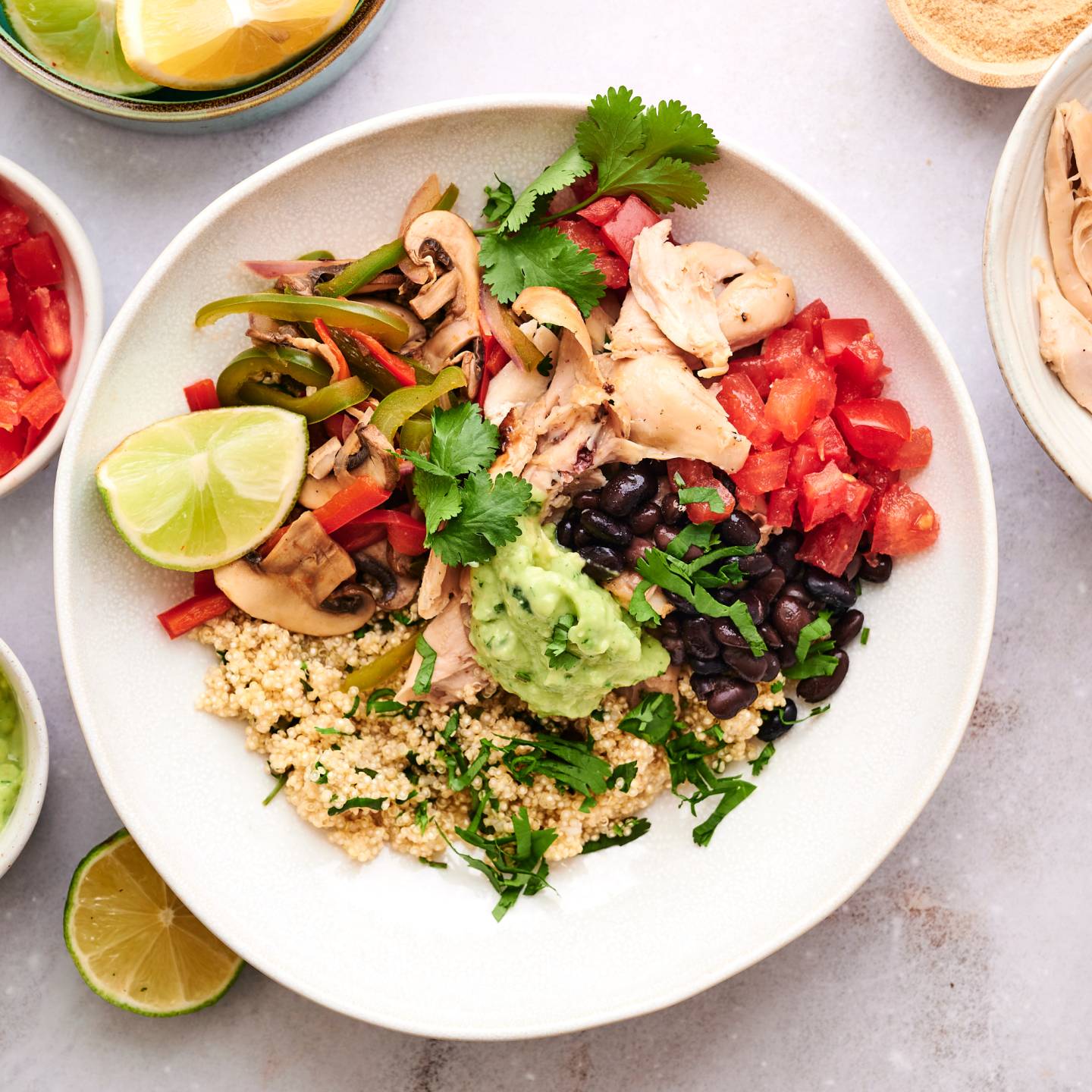 Rotisserie chicken taco bowl with black beans, bell peppers, onions, guacamole, and tomatoes.