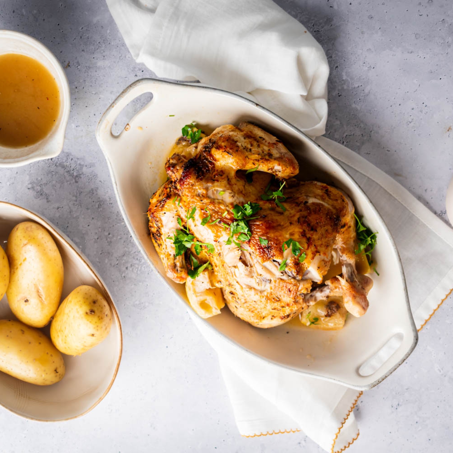 Slow cooker rotisserie chicken with a homemade spice rub, lemon, and parsley with potatoes on the side.