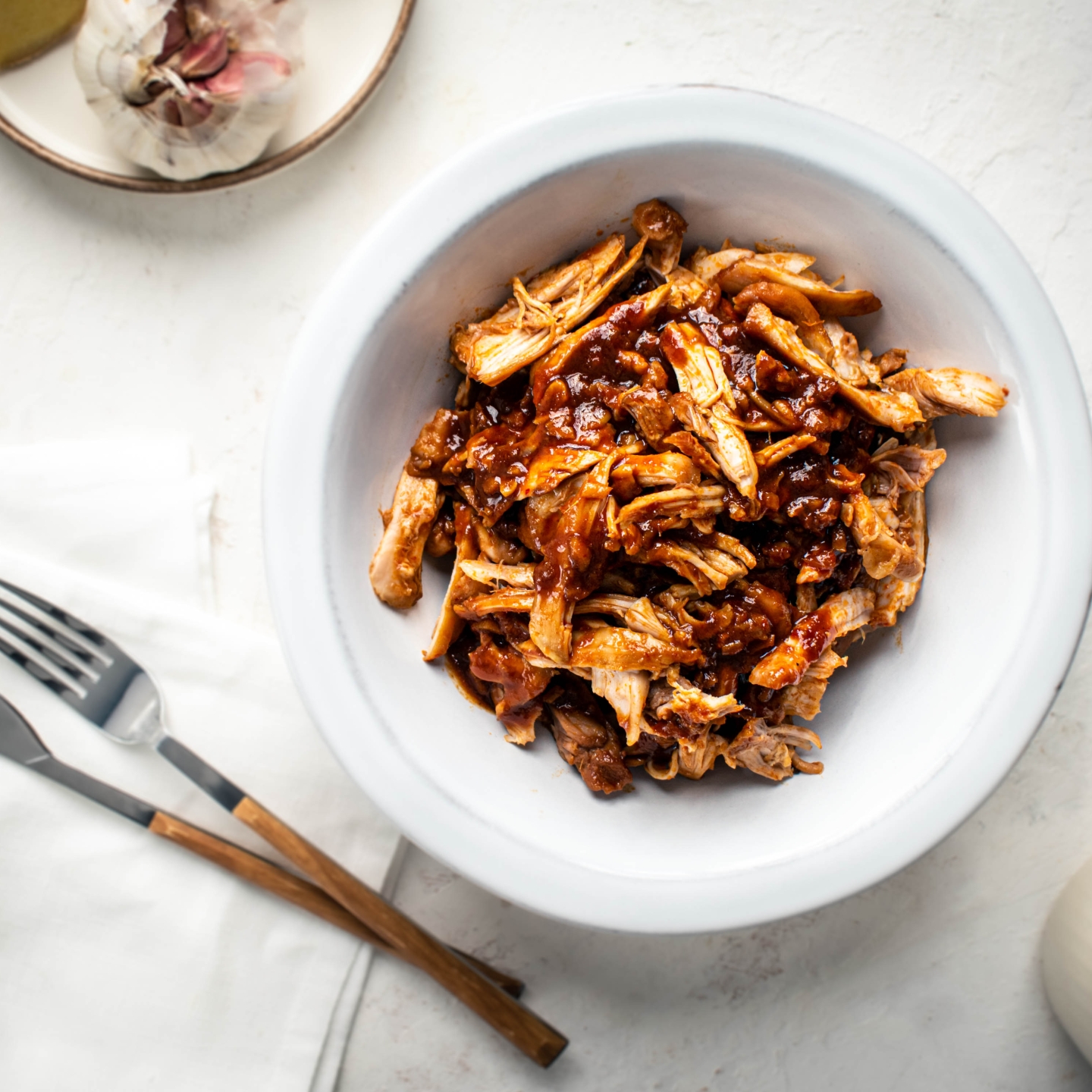 Slow cooker sweet and spicy chicken with soy sauce, Asian chili paste, and ginger in a bowl.