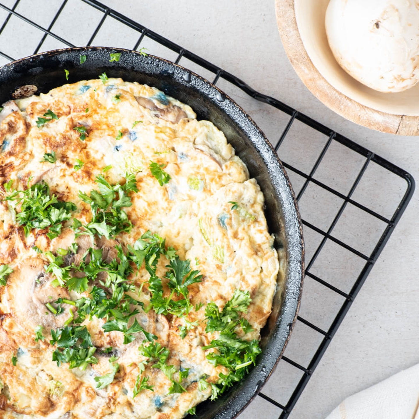 Vegetable and Hashbrown egg casserole in a cast iron skillet with fresh parsley.