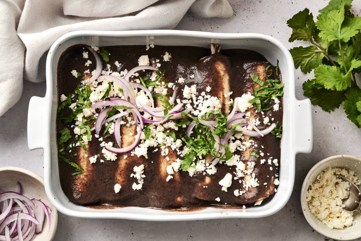 Enfrijoladas with chicken and black bean sauce in a pan ready to be served.