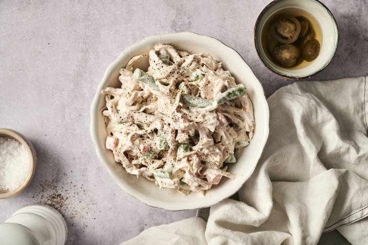 A bowl filled with Mexican Chicken Salad, garnished with black pepper.