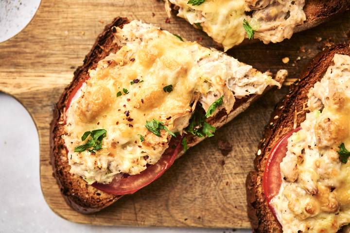 Healthy tuna melt served open faced with tomato slices and cheddar cheese.