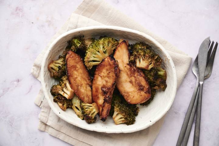 Sheet pan peanut chicken and broccoli with peanut sauce on a baking sheet.