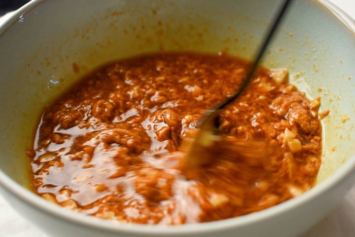 Peanut butter, soy sauce, maple syrup, lime juice, rice vinegar, and ginger in a bowl.